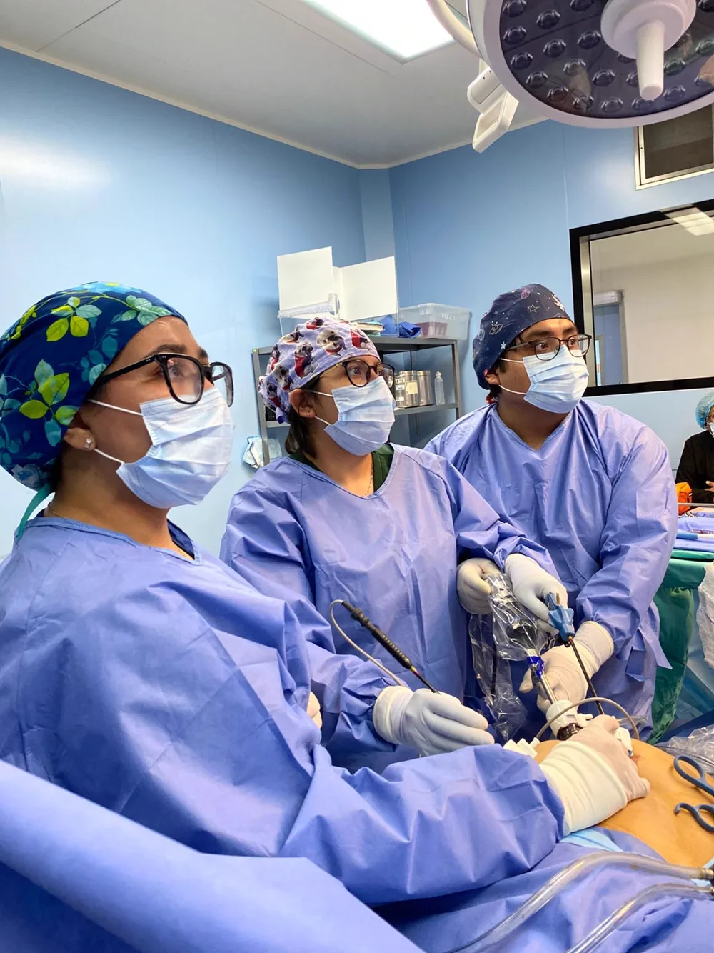 Equipo quirúrgico frente al monitor de laparoscopía durante una cirugía de mínima invasión.